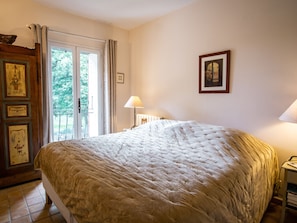 Cozy retreat with a large bed, wardrobe, and window with curtains.