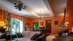 A living room with a sofa, a coffee table, and a dining area with chairs and a table.
