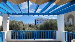 Un espacio al aire libre cubierto con barandillas azules y vistas a edificios al fondo.