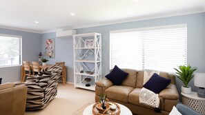 Relax in this stylish living room with a brown leather sofa, zebra-patterned armchair, and round coffee table.