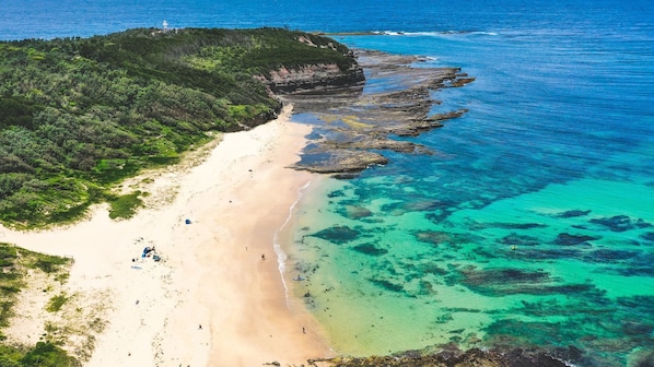 Enjoy a serene beach experience with clear waters and lush surroundings, perfect for snorkeling or diving.