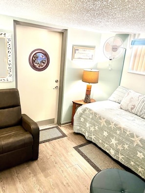 Cozy retreat with a single bed, bedside table, and wall-mounted fan.
