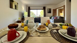Et morgenmåltid med tallerkener, kopper og en kande appelsinjuice på et bord.