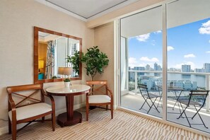 Enjoy a panoramic view of the city skyline and water from the balcony, featuring a table and chairs for relaxation or dining.