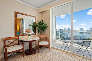 Enjoy a panoramic view of the city skyline and water from the balcony, featuring a table and chairs for relaxation or dining.