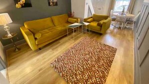 A living room with a yellow sofa, a coffee table, and a patterned rug. - Townhouse near to Castle, Cathedral and Bailgate (Lincoln)