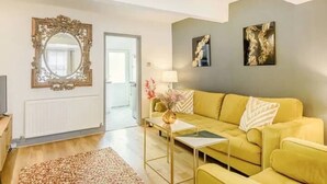 A living room with a yellow sofa, a mirror, and two wall art pieces. - Townhouse near to Castle, Cathedral and Bailgate (Lincoln)