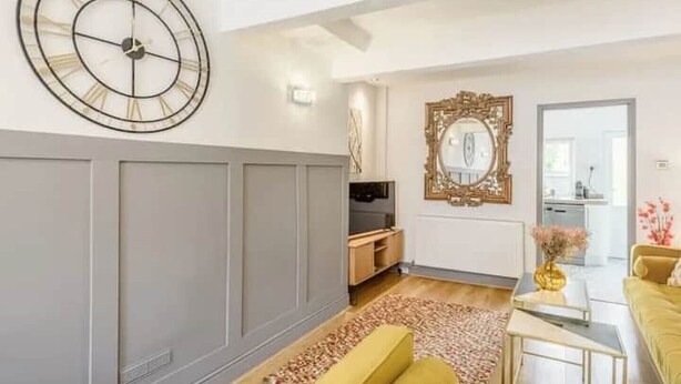 A living room with a large wall clock, a mirror, and a sofa. - Townhouse near to Castle, Cathedral and Bailgate (Lincoln)