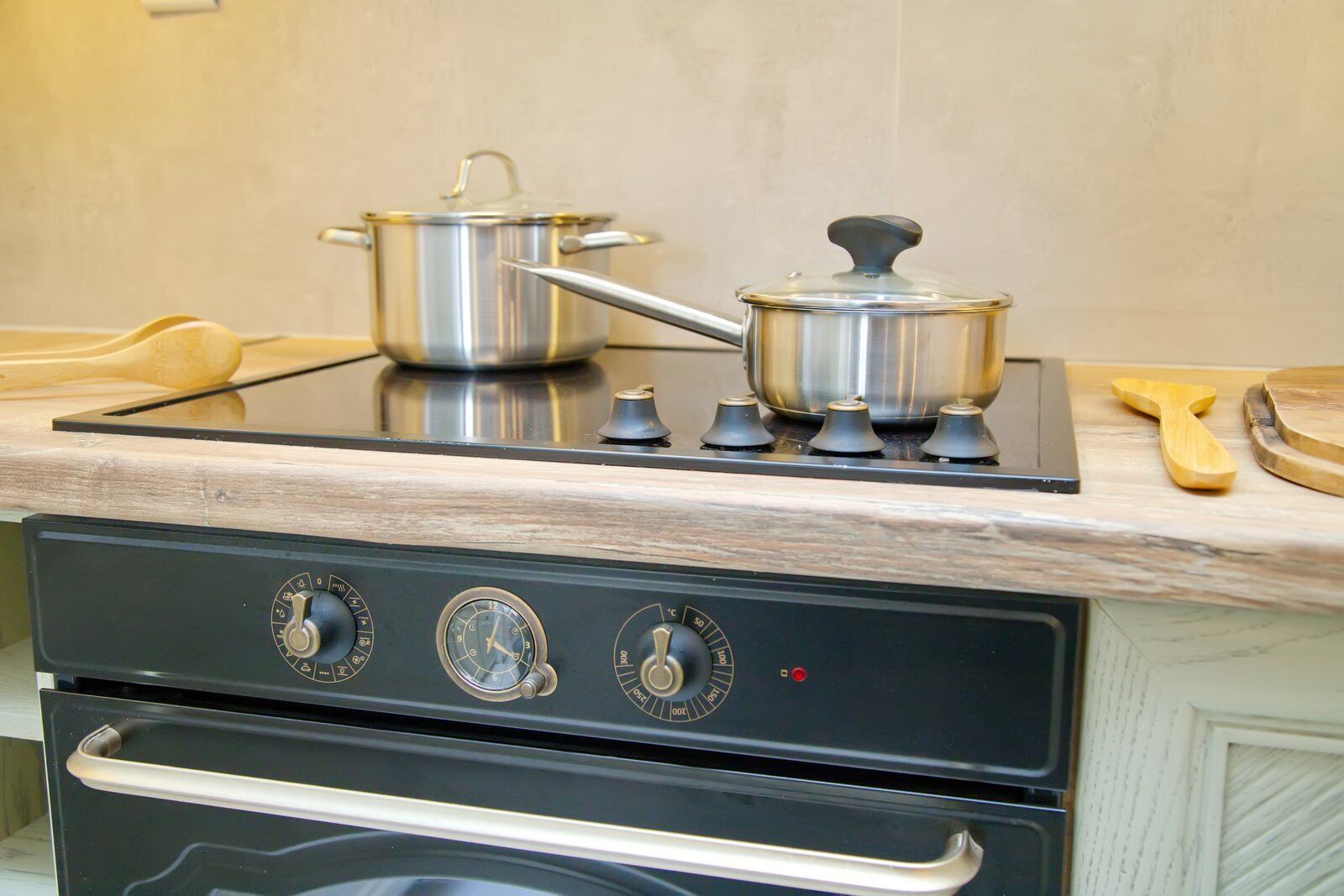 A kitchen with a stove, pots, and wooden utensils.