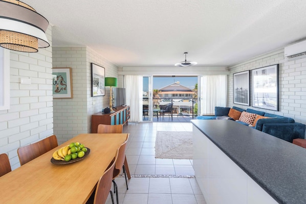 A modern kitchen with a dining area, a large island, and a view to the outside.