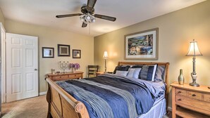A bedroom with a bed, a ceiling fan, a nightstand, a lamp, and framed pictures on the wall. - Family Home Near Panola Mountain State Park! (Stonecrest)