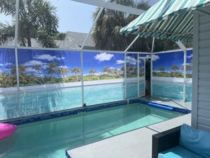 Ein Schwimmbad mit Blick auf Palmen und einen klaren Himmel.