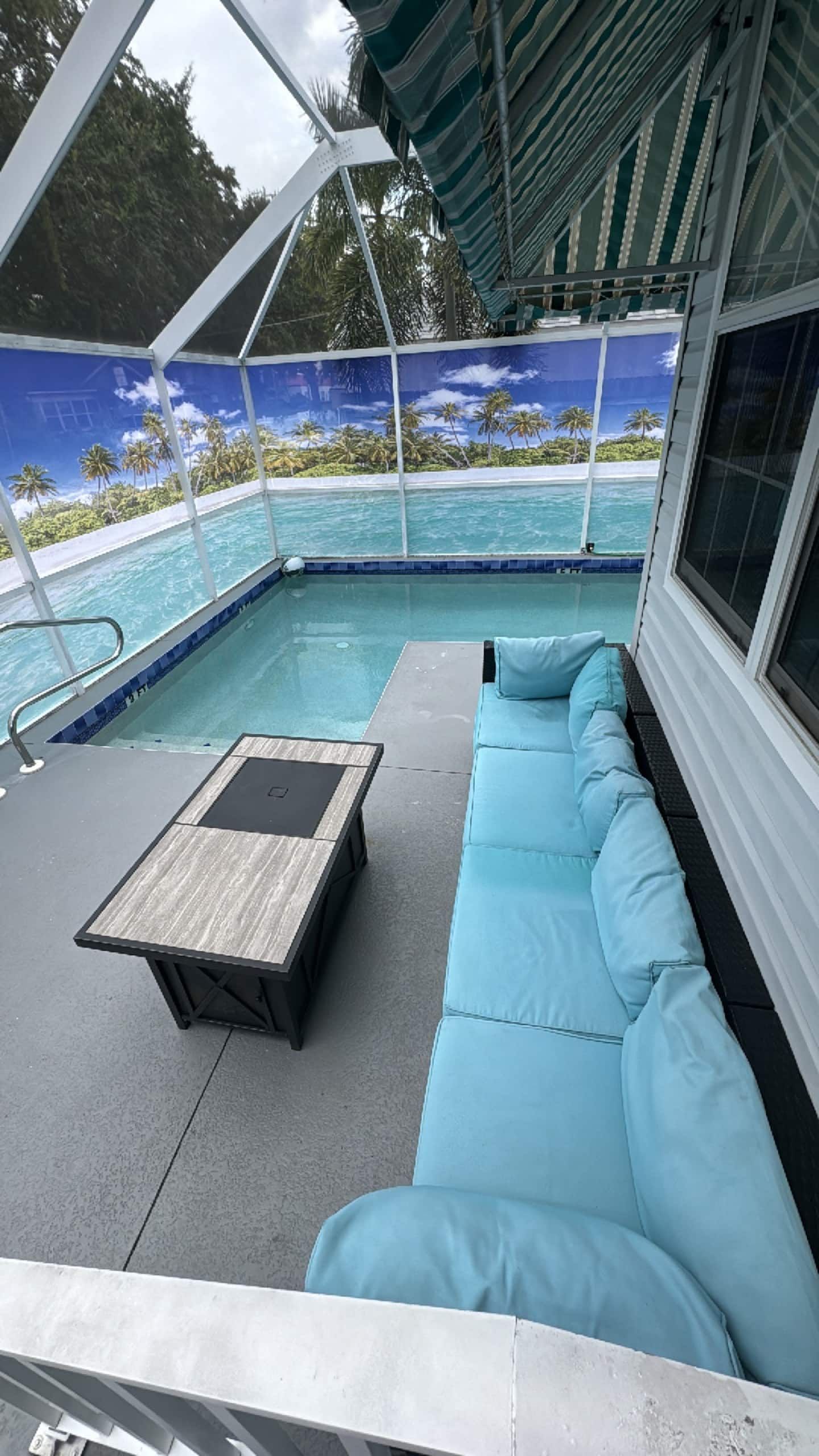 A poolside area with a seating area and a view of the ocean.