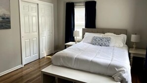 A bedroom with a bed, bedside tables, a bench, a window with curtains, and a door. - Newly renovated- 2.5 mi to Downtown Riverfront (Owensboro)