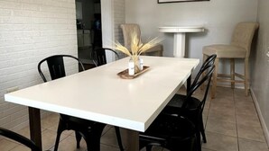 A dining area with a white table, black chairs, and a vase with dried plants. - Newly renovated- 2.5 mi to Downtown Riverfront (Owensboro)
