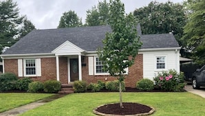 A two-story house with a brick facade, white trim, and a dark roof. - Newly renovated- 2.5 mi to Downtown Riverfront (Owensboro)