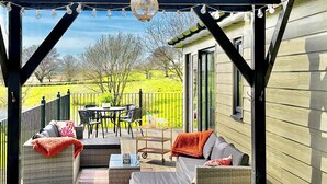 Un patio couvert avec des meubles d’extérieur, une table et des chaises.