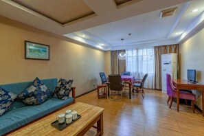 Uma sala de estar com sofá, mesa de centro e área de jantar com cadeiras e mesa.
