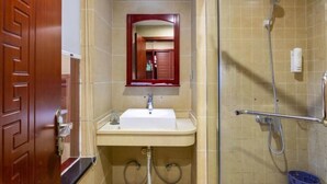 A bathroom with a sink, mirror, and shower. - Fulante Le Hotel (Tianmen Mountain Fengwan Road) (Zhangjiajie)