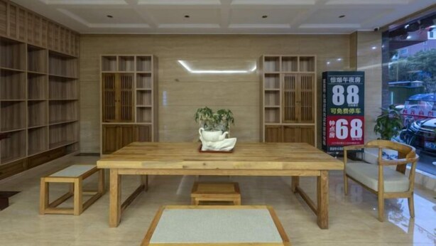 A modern interior with a wooden table, benches, and bookshelves. - Fulante Le Hotel (Tianmen Mountain Fengwan Road) (Zhangjiajie)