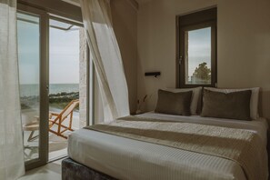 A bedroom with a bed, a window, and a view of the sea. - Nama Seaside Villas (Preveza)