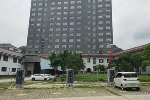 Un edificio de varios pisos con un estacionamiento al frente.