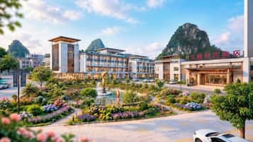 A hotel with a central courtyard, a fountain, and a mountain backdrop.