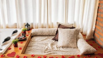 A cozy room with a sofa, a small table with a candle, and a decorative lantern.