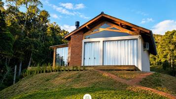 Una casa moderna con garaje, rodeada de vegetación.