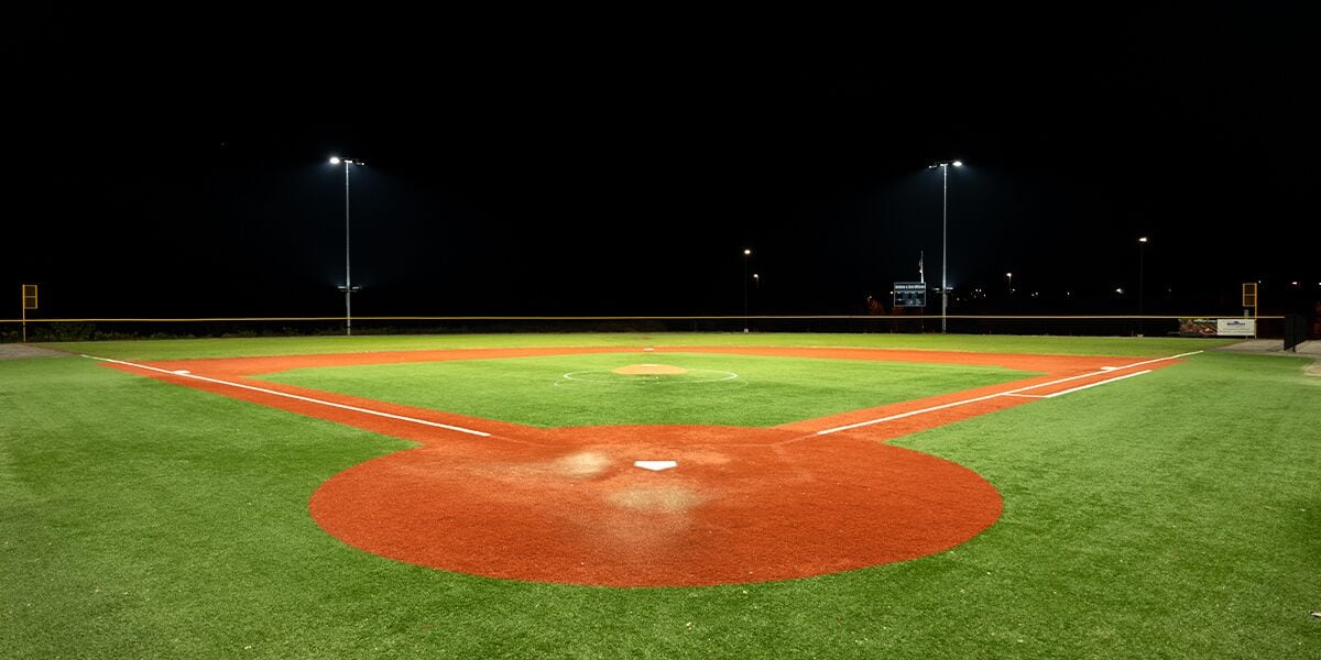 A baseball field at night with artificial lighting.
