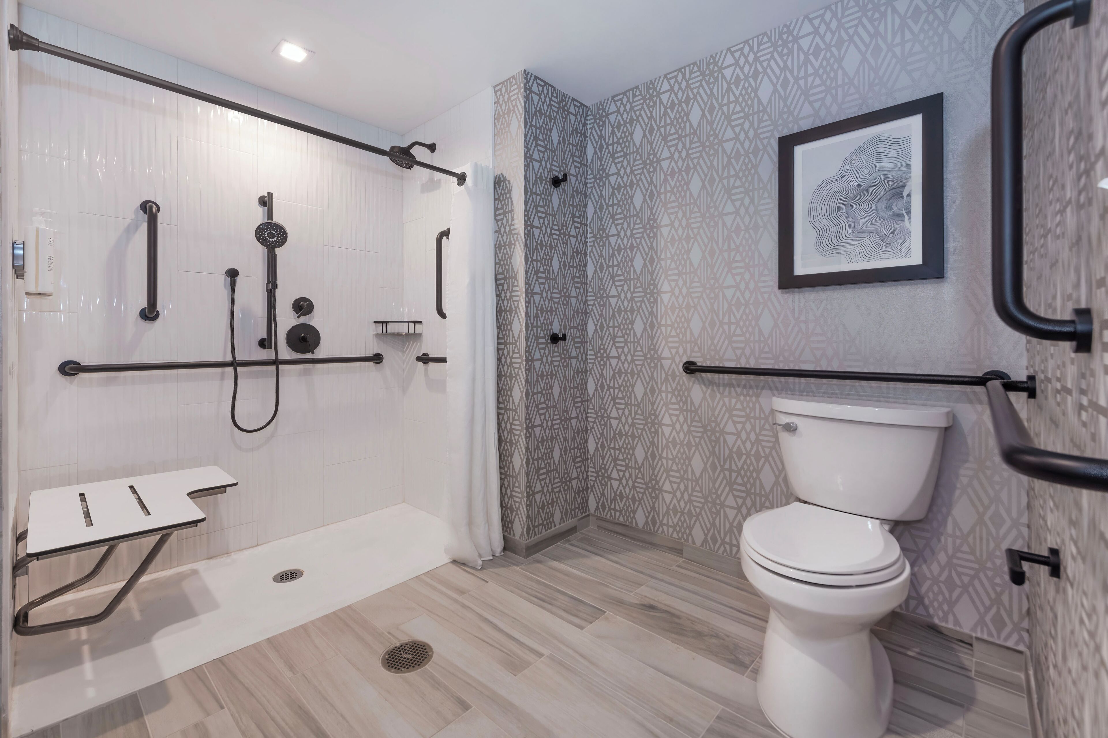 Une salle de bain moderne équipée d’une douche, de toilettes et d’un petit lavabo.