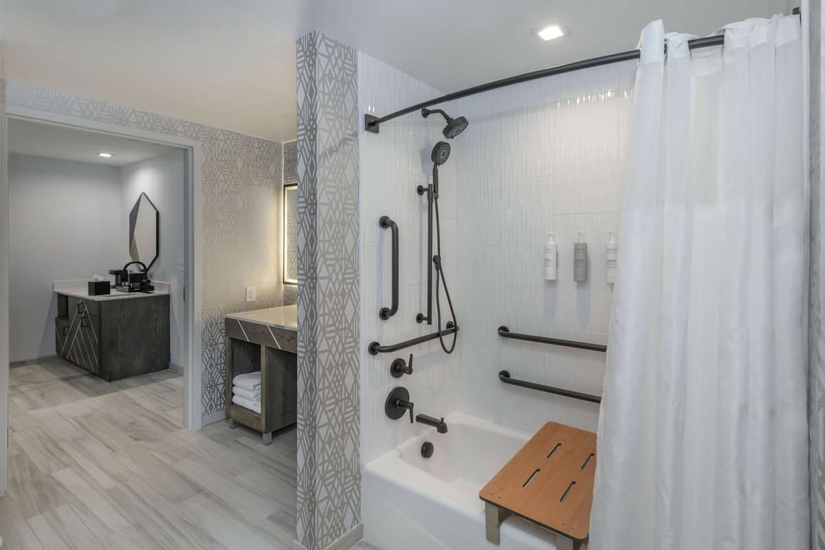 A modern bathroom with a shower, bathtub, and vanity.
