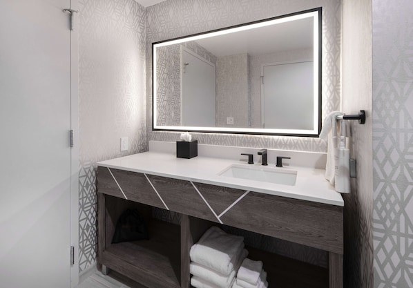 A modern bathroom with a large mirror, white sink, and wooden vanity. - Embassy Suites By Hilton Asheville Downtown (Asheville)