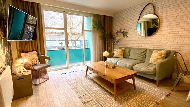 A modern living room with a sofa, coffee table, and TV.