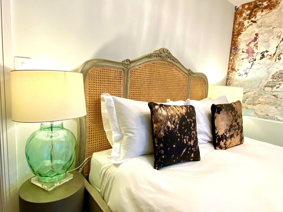A hotel room with a bed, a lamp, and a headboard.