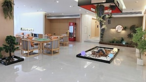 A modern hotel lobby with a reception desk, seating area, and decorative plants. - Jianmen Star Hotel (Jiange)