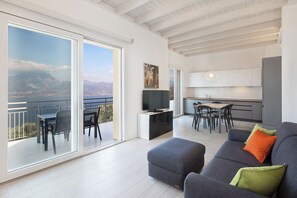 A modern living room with a balcony, a dining area, and a kitchen. - Villa Malù - APT Luisa Pool and lake view (Torri del Benaco)