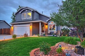 Stunning two-story home with a beautifully landscaped yard and a garage door.