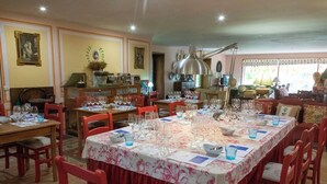 A dining area with multiple tables set for a meal, chairs, and a large window with a view. - Casa de Juste (Lousada)