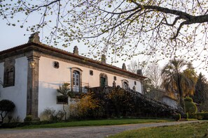 Un edificio histórico con fachada simétrica, ventanas arqueadas y una entrada central.