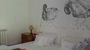 A neatly made bed with white linens, a checkered blanket, and a wall mural of owls. - Casa de Juste (Lousada)