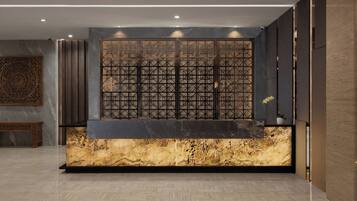A reception area with a marble counter, a decorative screen, and a patterned floor.