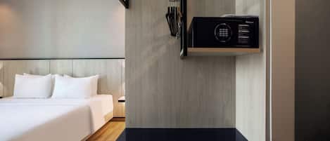 A hotel room with a bed, a black countertop, a microwave, and a wall-mounted towel rack.