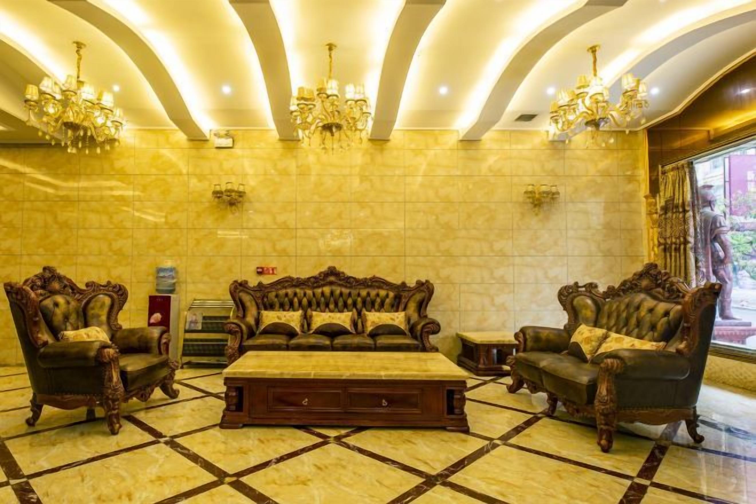 A lobby with a large sofa set, a coffee table, and a chandelier.