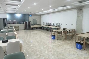 A conference room with a long table, chairs, and a projector screen.