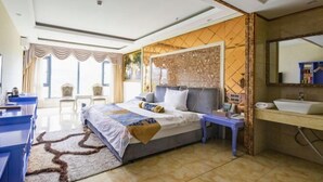 Un dormitorio moderno con una cama grande, una mesita de noche, un tocador con espejo y vistas al exterior a través de una ventana.