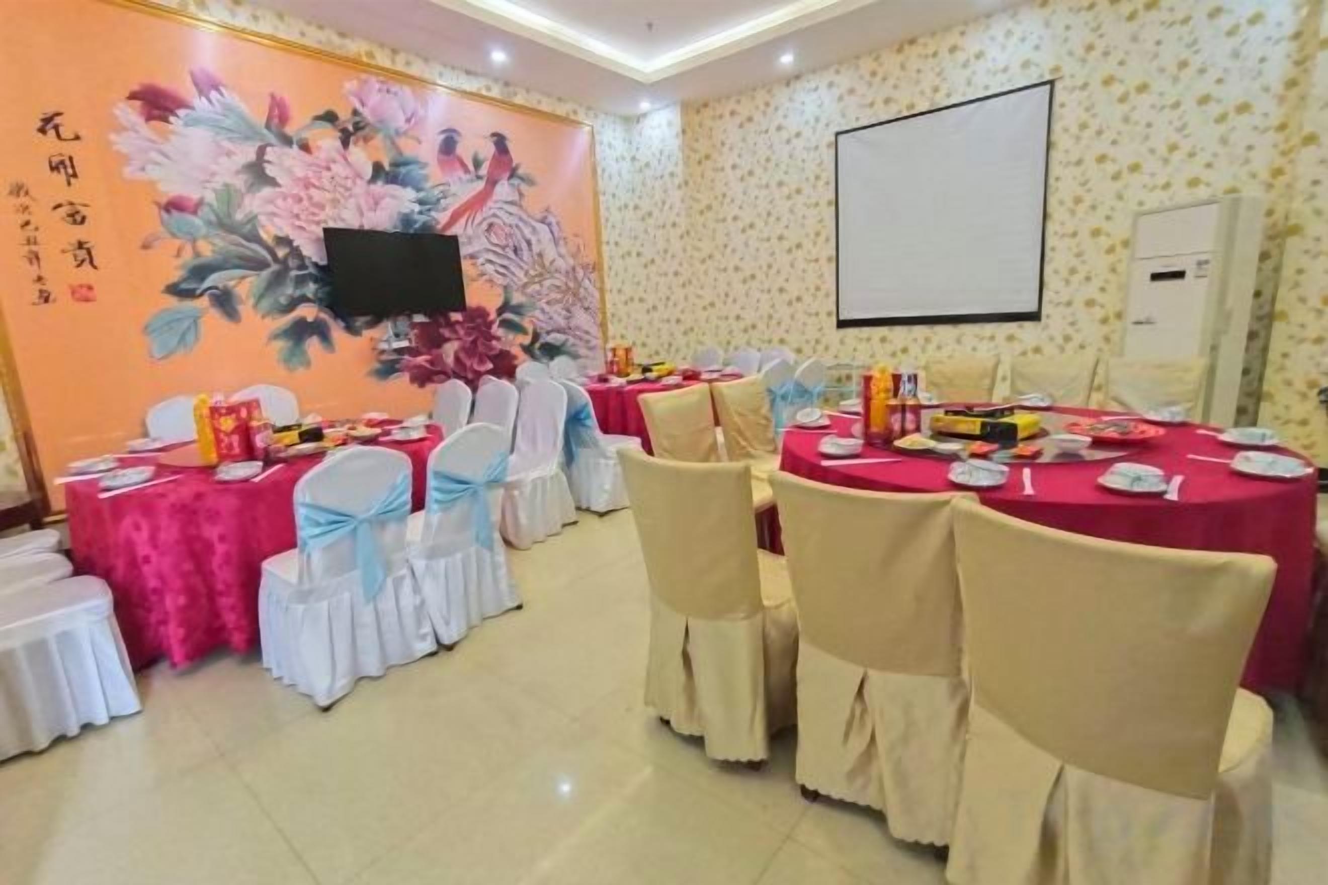 A conference room with round tables, chairs, and a projector screen.