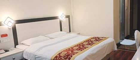 Habitación de hotel con una cama individual, una mesita de noche con teléfono y dos lámparas de pared.