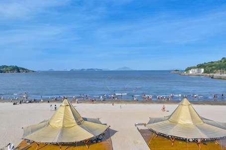 A beach with tents and a clear view of the sea.. Tinghai Guesthouse
