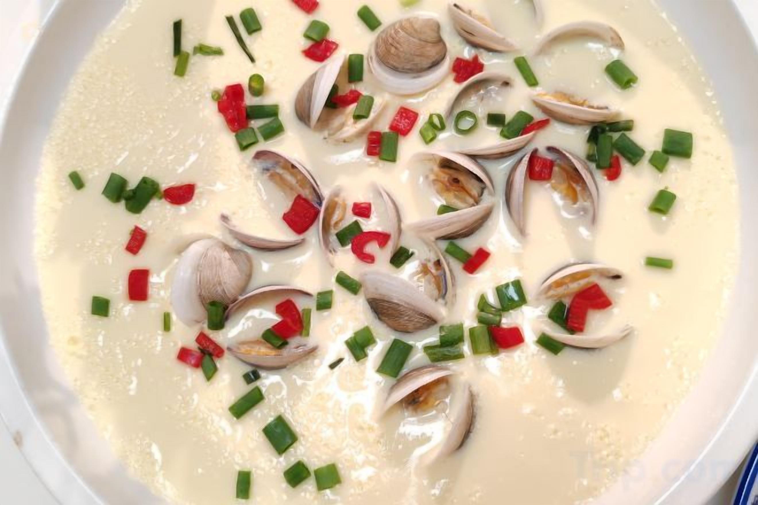 A creamy soup with clams and chopped green onions.